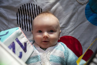 High angle view of cute baby girl lying on bed