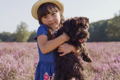 Full length of girl with dog on field