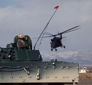 Helicopter flying over water against sky