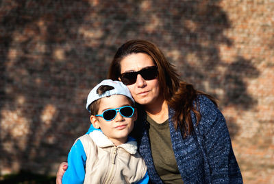 Portrait of smiling mother embracing cute son