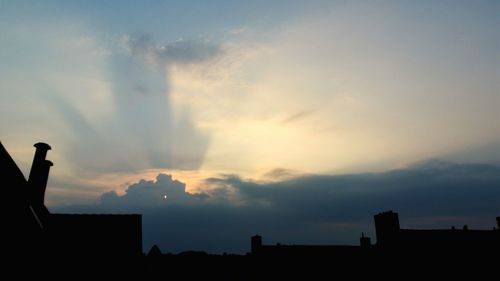 Silhouette of city against sky during sunset