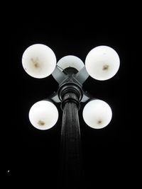 Low angle view of illuminated light bulbs hanging on ceiling