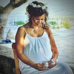 Portrait of young woman sitting on wall