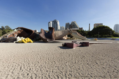 Lifeguard hut on beach in city against blue sky