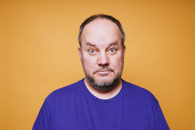 Portrait of man against yellow background