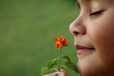Close-up portrait of girl holding flowering plant 