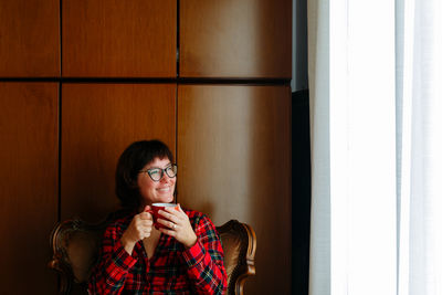 Young woman drinking water at home