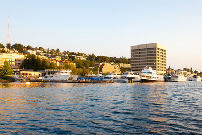 Buildings by sea against clear sky