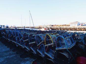 Boats moored at harbor against clear sky