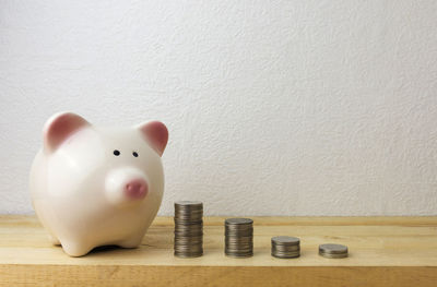 Close-up of coins on table against wall