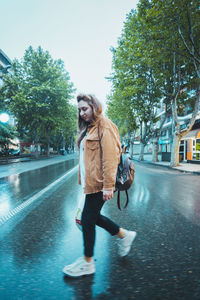 Full length of woman walking on road in city