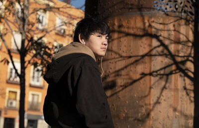 Asian teenage boy with earphones on street. madrid. spain