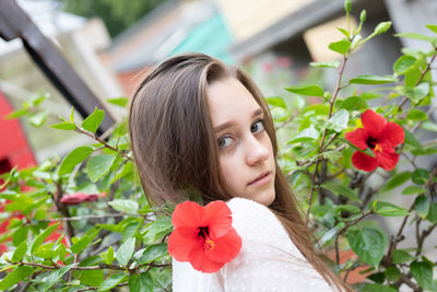 Portrait of woman with red flowers