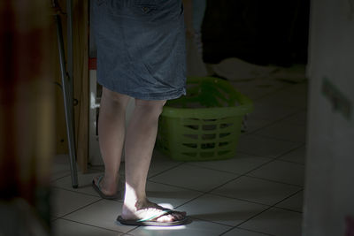 Low section of woman standing on tiled floor