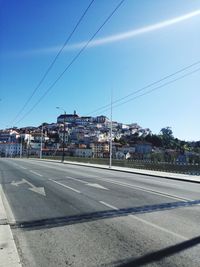 Road by city against blue sky