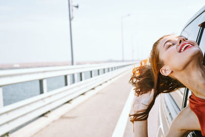 Woman on railing against sky