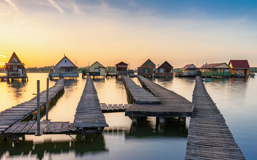 Pier over lake against sky during sunset