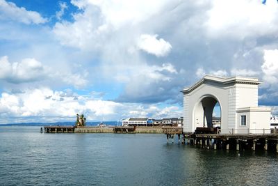 Arch structure on pier over sea against sky