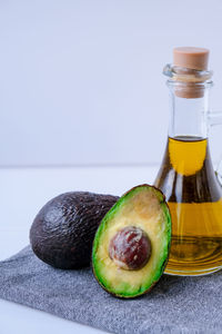 Pitcher of natural oil and fresh ripe hass avocados. preparing food in the kitchen. ingredients. 