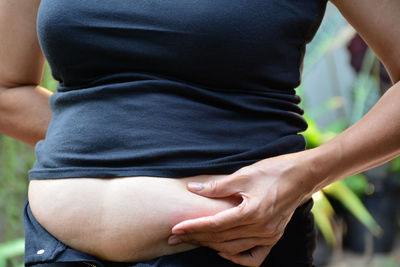 Close-up of woman holding belly fat