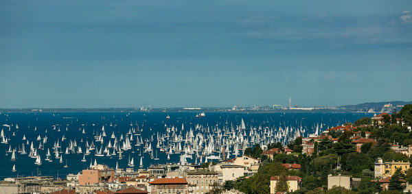 Cityscape by sea against sky