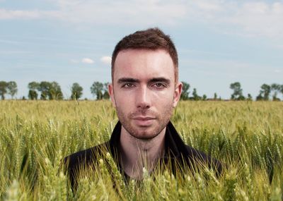 Portrait of man amidst plants against sky