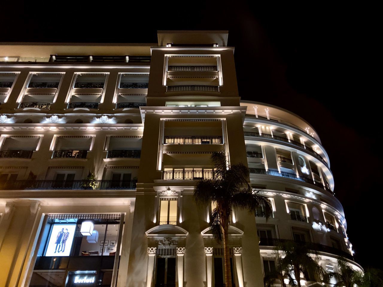 LOW ANGLE VIEW OF ILLUMINATED BUILDINGS AGAINST SKY AT NIGHT