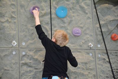 A boy climbs on a wall