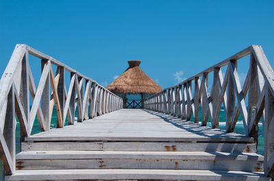 Wooden footbridge against clear blue sky