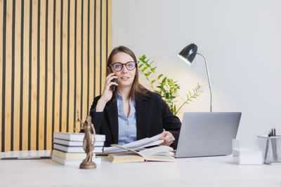 Young woman using laptop while sitting on table