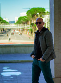 Portrait of young man standing against wall
