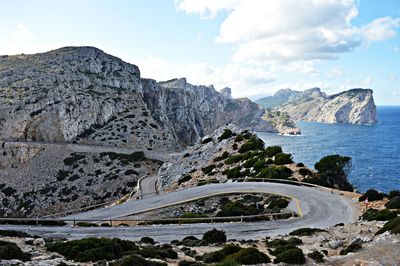 Scenic view of mountain by sea against sky