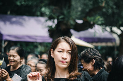 Portrait of a young woman looking away outdoors