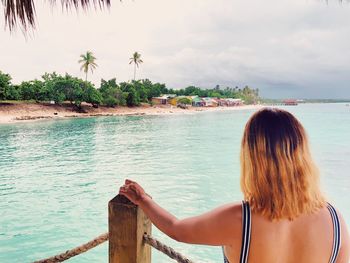 Rear view of woman looking at sea against sky