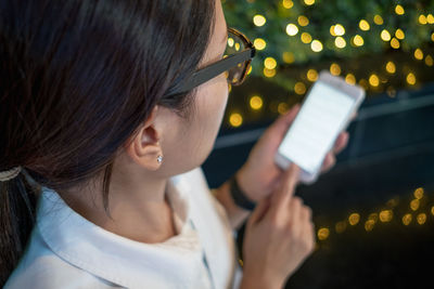 Midsection of woman using mobile phone at night