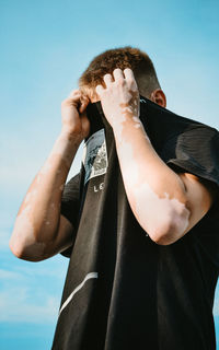 Low section of man standing against sky