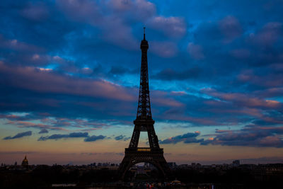 Communications tower against cloudy sky