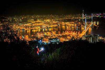 High angle view of illuminated buildings by river at night