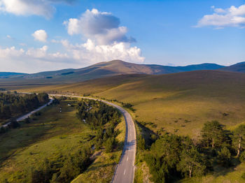 Scenic view of road leading towards mountains against sky