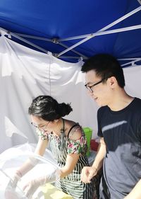 Smiling man and woman standing outdoors on sunny day