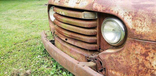 Close-up of old abandoned truck on field