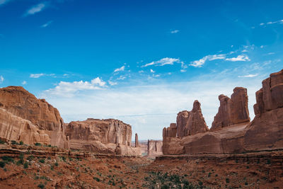 Rock formations on landscape against blue sky