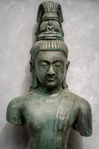 Close-up of buddha statue against wall