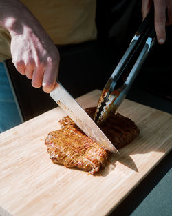 Midsection of person preparing meat on cutting board