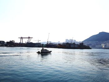 Boat sailing on river against clear sky