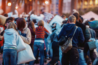 Rear view of people walking on city street