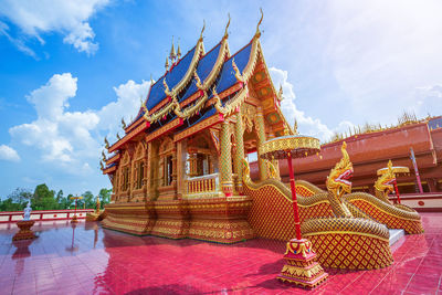 Low angle view of statue against temple building against sky