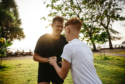 Happy father and son playing together in park during sunset