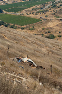 Hill side of dry grass and metal scrap on mine field