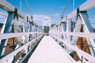 View of footbridge against blue sky